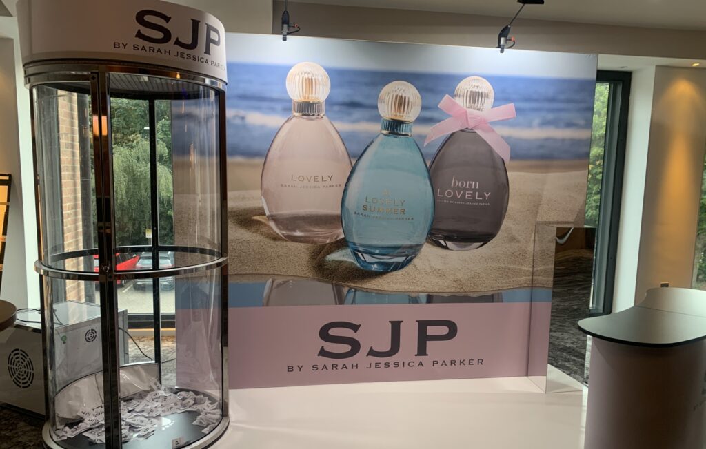 Display with three SJP perfumes and a branded booth for Sarah Jessica Parker’s fragrance line.